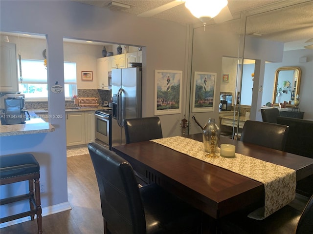 dining area with dark hardwood / wood-style floors and a textured ceiling