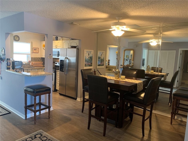 dining room with hardwood / wood-style floors and a textured ceiling