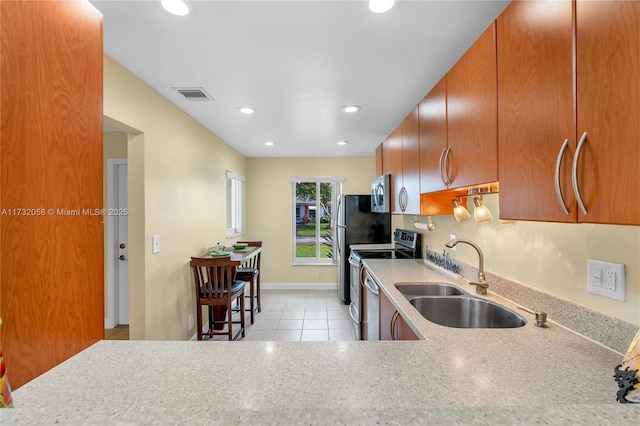 kitchen with light tile patterned flooring, appliances with stainless steel finishes, and sink