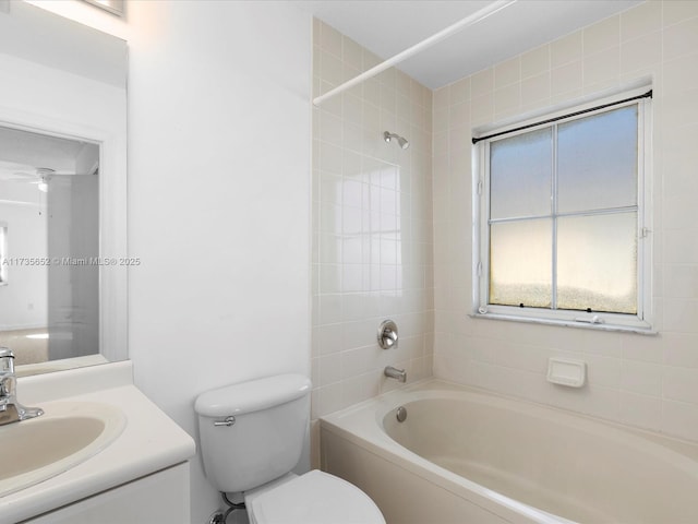 full bathroom with tiled shower / bath, vanity, and toilet