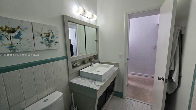 bathroom with sink, tile walls, and toilet