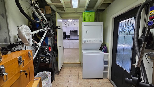 laundry room with stacked washer and dryer and light tile patterned floors