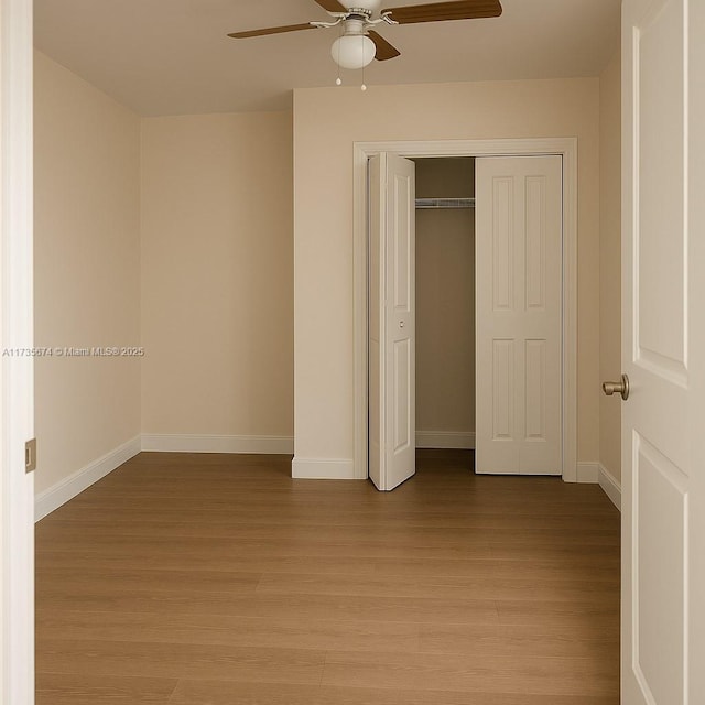 unfurnished bedroom with light wood-style floors, a closet, a ceiling fan, and baseboards