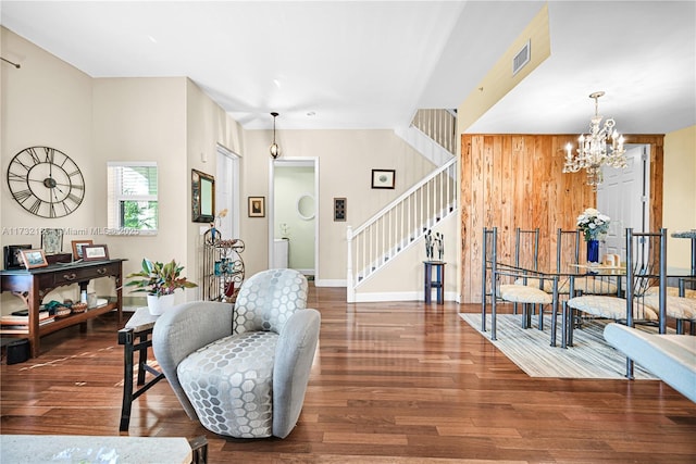 interior space featuring wooden walls, dark hardwood / wood-style floors, and a chandelier