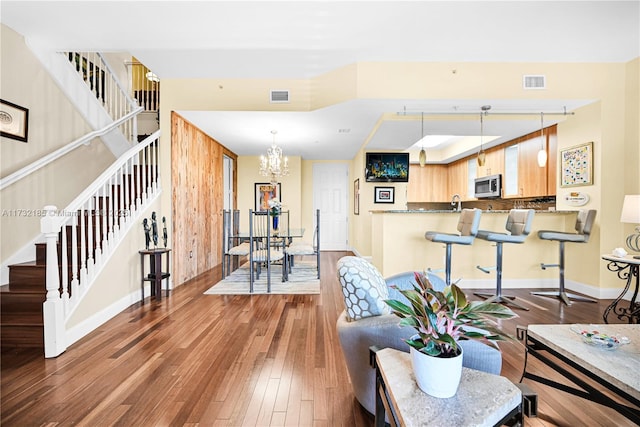 living room with a notable chandelier and wood-type flooring