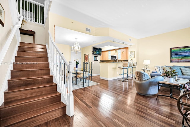 stairway featuring an inviting chandelier and hardwood / wood-style flooring