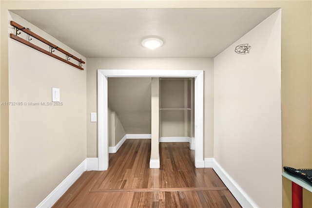 corridor with hardwood / wood-style floors