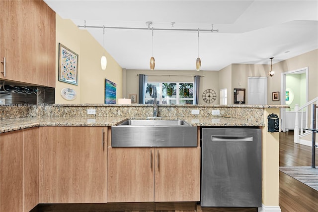 kitchen featuring light stone countertops, stainless steel dishwasher, and sink