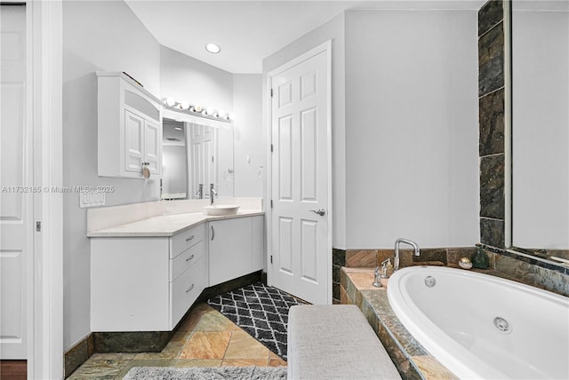 bathroom featuring vanity and tiled bath