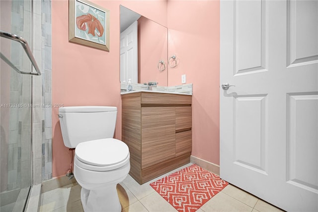 bathroom featuring tile patterned flooring, vanity, a shower with door, and toilet