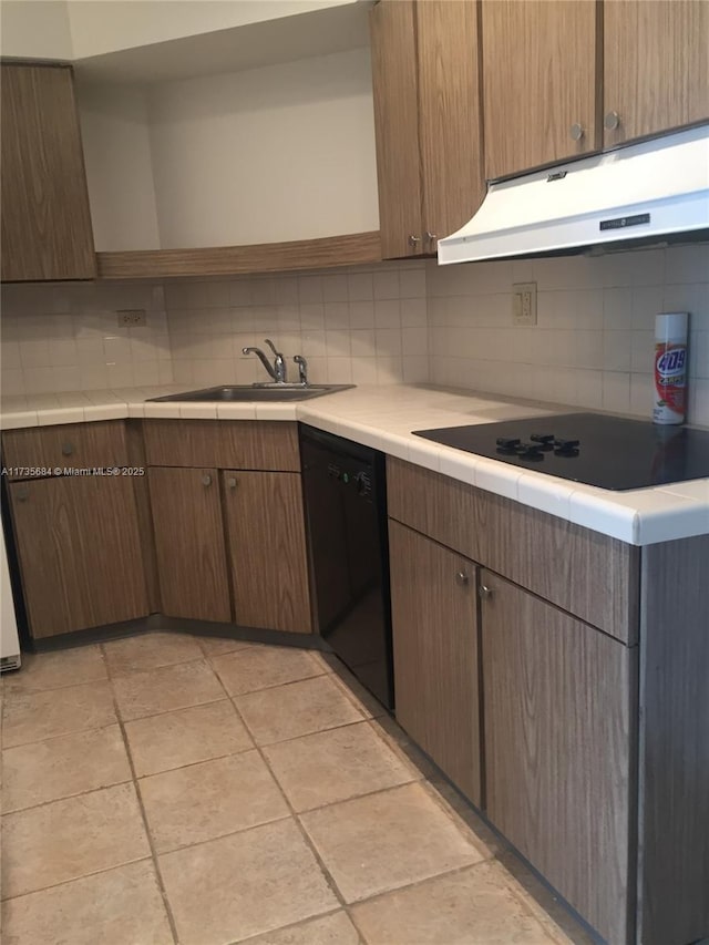 kitchen with light tile patterned floors, sink, decorative backsplash, and black appliances