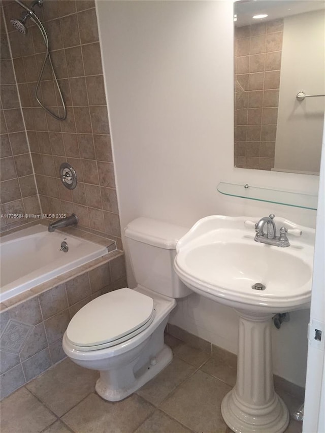 full bathroom featuring tiled shower / bath, sink, toilet, and tile patterned flooring