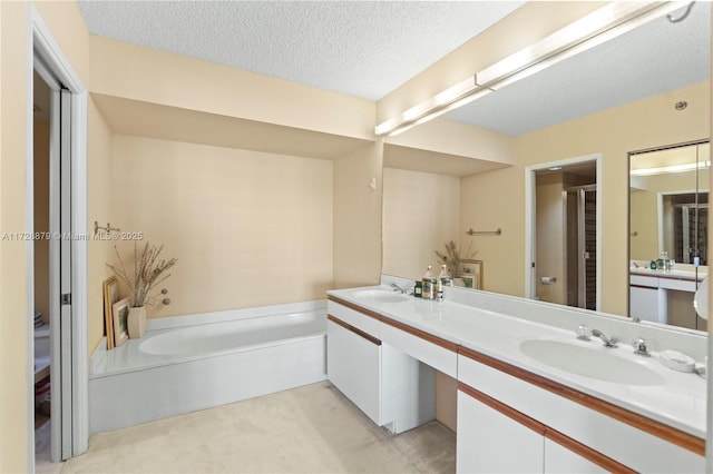 full bathroom featuring a garden tub, a shower stall, a textured ceiling, and a sink