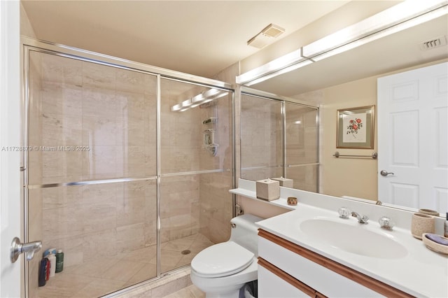 bathroom with toilet, vanity, a shower stall, and visible vents