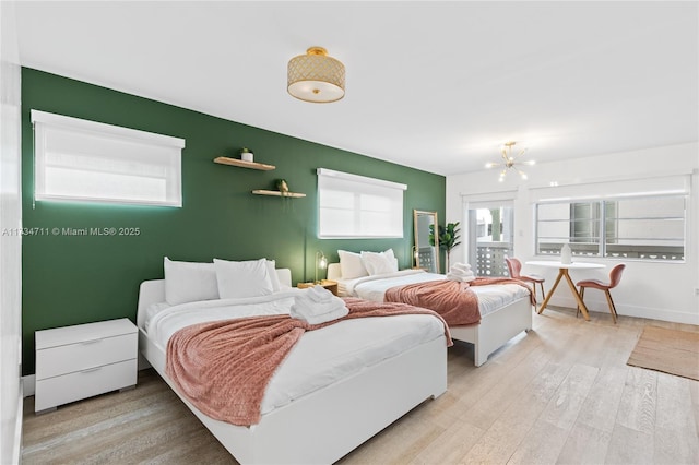 bedroom featuring an inviting chandelier and light hardwood / wood-style floors