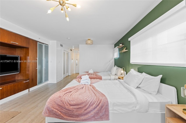 bedroom featuring light hardwood / wood-style floors and a chandelier