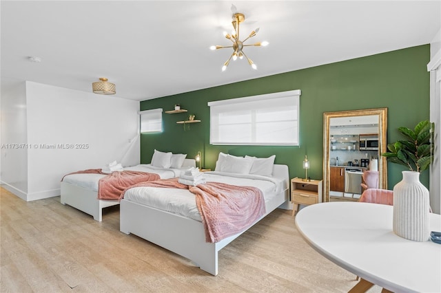 bedroom with a chandelier and light hardwood / wood-style floors