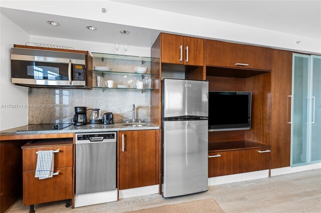 kitchen with tasteful backsplash, appliances with stainless steel finishes, light hardwood / wood-style floors, and sink