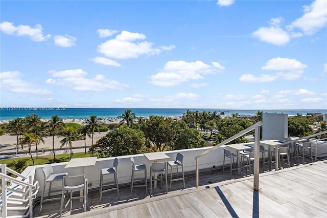 wooden deck with an outdoor bar and a water view