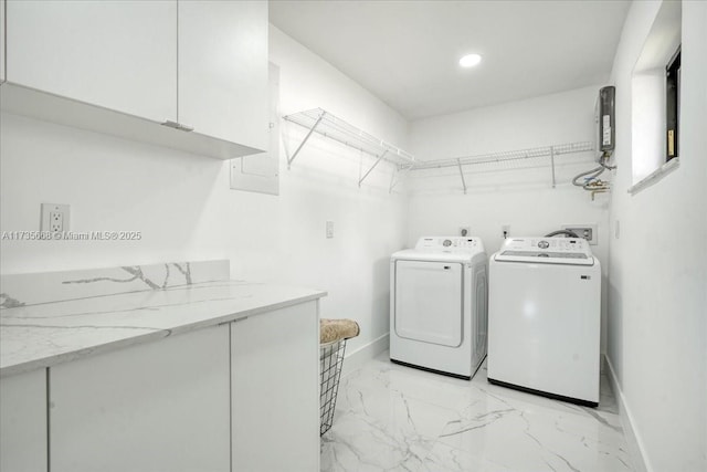 clothes washing area with cabinets and washer and dryer