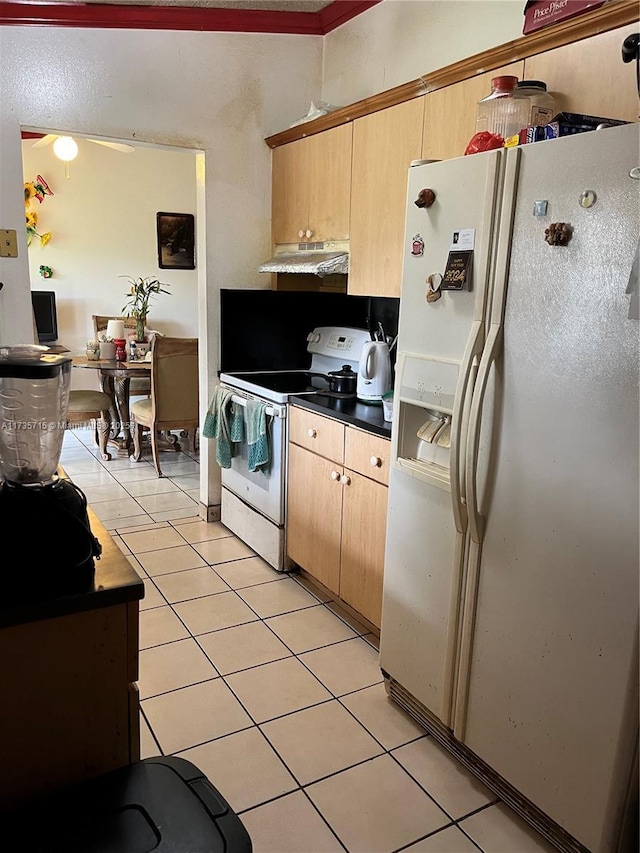 kitchen with light tile patterned floors, white appliances, and light brown cabinets