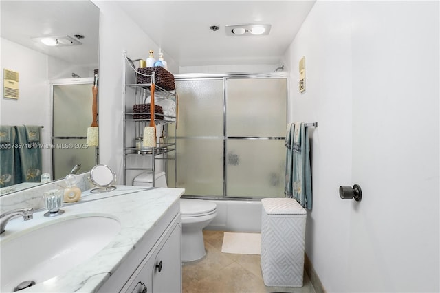 full bathroom featuring bath / shower combo with glass door, vanity, tile patterned floors, and toilet