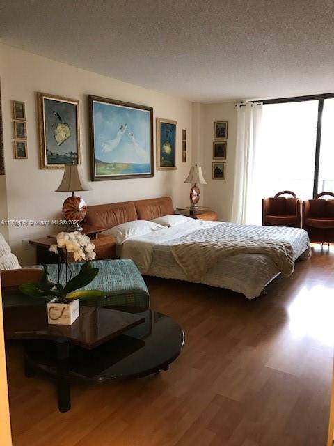 bedroom with hardwood / wood-style floors and a textured ceiling