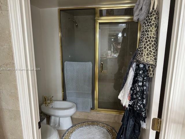 bathroom with tile patterned floors, a bidet, toilet, and a stall shower