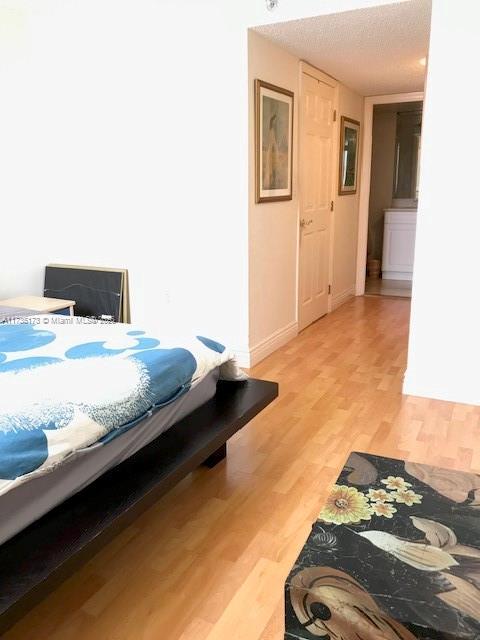 bedroom featuring light wood-style floors and baseboards