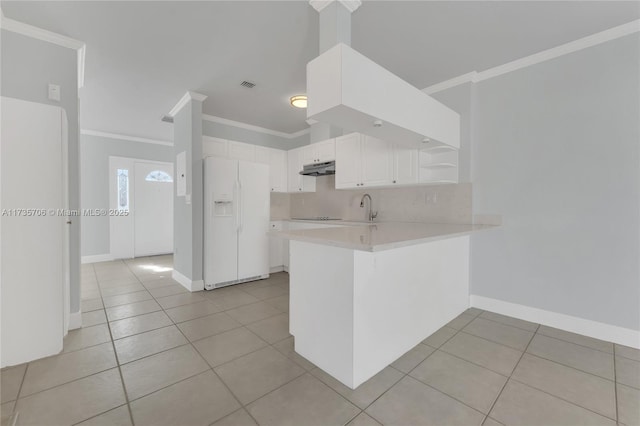 kitchen with light tile patterned flooring, white cabinetry, kitchen peninsula, white refrigerator with ice dispenser, and backsplash