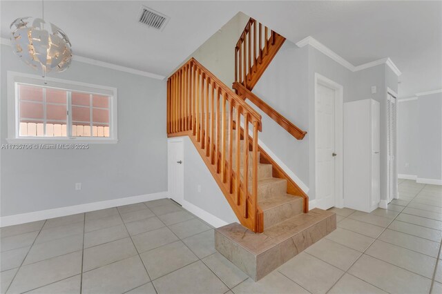 stairway with a notable chandelier, crown molding, and tile patterned floors