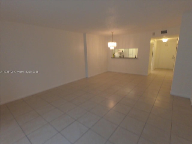 unfurnished room featuring an inviting chandelier