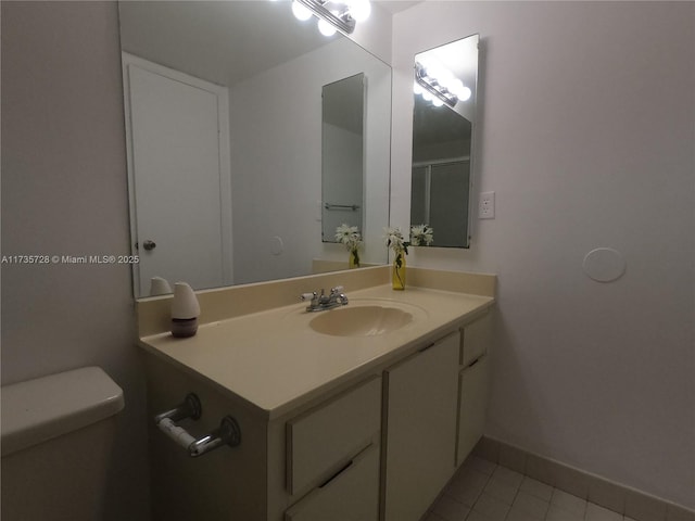 bathroom featuring vanity, tile patterned floors, and toilet