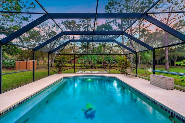 pool at dusk with a yard, a lanai, and a patio area