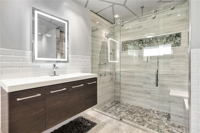 bathroom featuring vanity, tile walls, and walk in shower