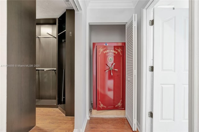 corridor featuring crown molding and light hardwood / wood-style flooring