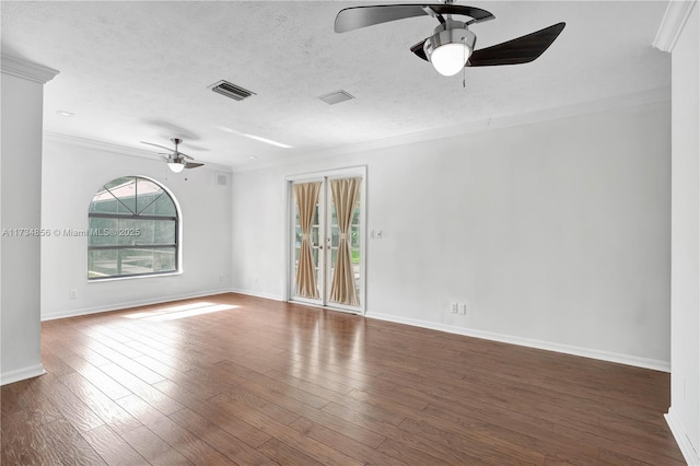 empty room featuring dark hardwood / wood-style flooring, ceiling fan, ornamental molding, and a textured ceiling