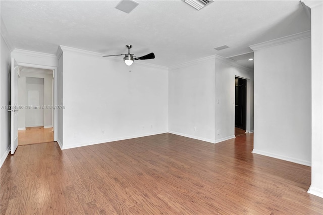 empty room featuring hardwood / wood-style flooring, ornamental molding, a textured ceiling, and ceiling fan