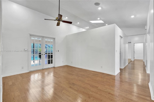 unfurnished living room with high vaulted ceiling, light hardwood / wood-style floors, french doors, and ceiling fan