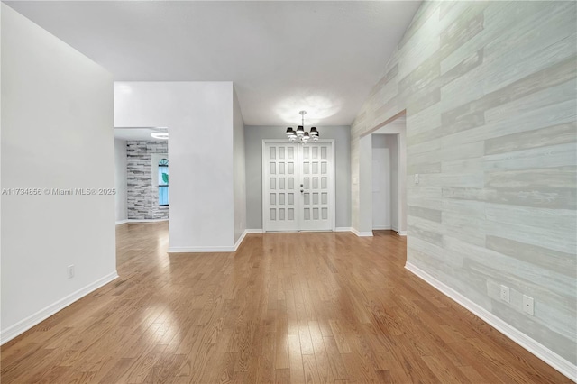 empty room with an inviting chandelier and light wood-type flooring