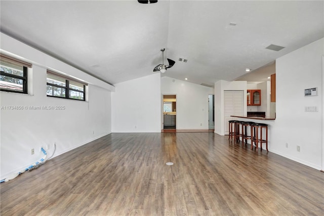 unfurnished living room featuring hardwood / wood-style flooring and lofted ceiling