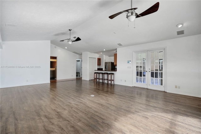 unfurnished living room with lofted ceiling, dark hardwood / wood-style flooring, french doors, and ceiling fan