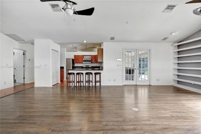 living room featuring vaulted ceiling, ceiling fan, dark hardwood / wood-style flooring, and french doors