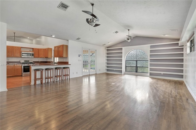 living room featuring ceiling fan, lofted ceiling, wood-type flooring, and built in features