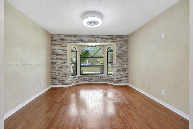 13230 N 153rd Rd N, Jupiter, FL 33478 - spare room with wood-type flooring, a textured ceiling, and baseboards