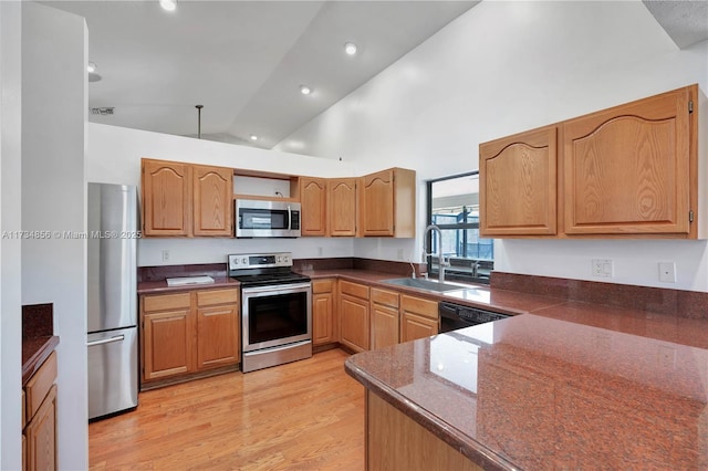 kitchen with sink, high vaulted ceiling, kitchen peninsula, stainless steel appliances, and light hardwood / wood-style floors