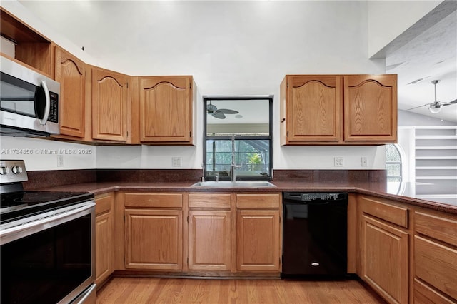 kitchen with lofted ceiling, sink, light hardwood / wood-style flooring, ceiling fan, and stainless steel appliances