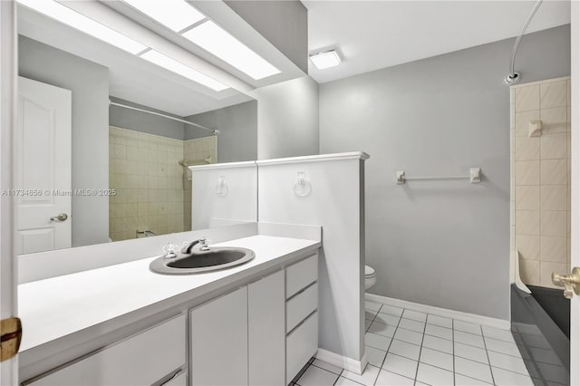 bathroom featuring a skylight, vanity, tile patterned floors, and toilet