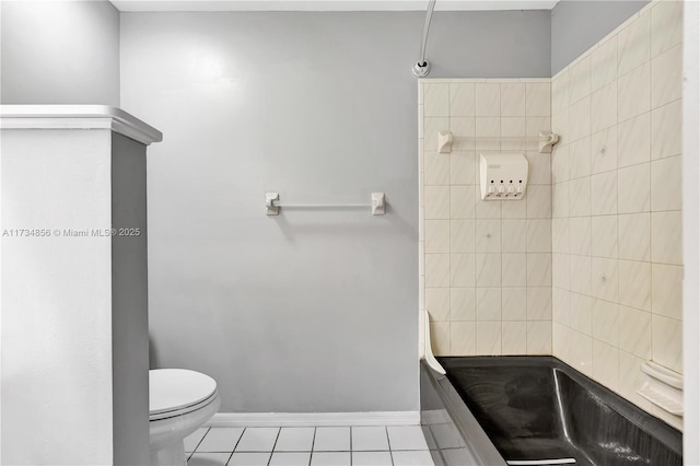 bathroom featuring a tile shower, tile patterned floors, and toilet