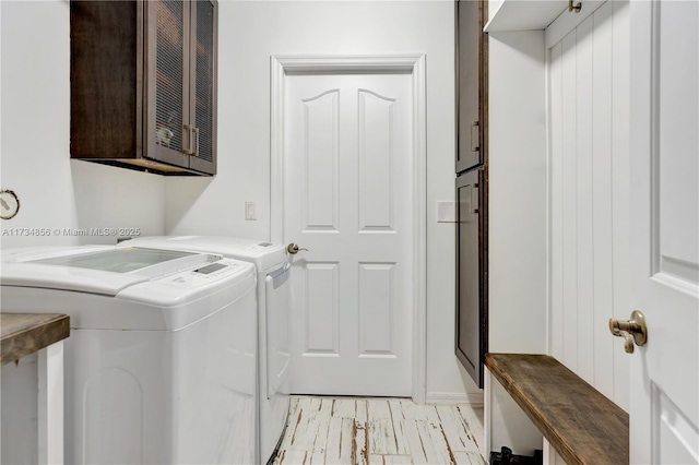 washroom with cabinets and washing machine and dryer